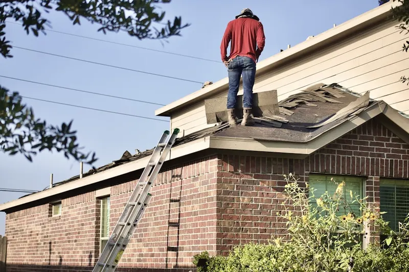 Professional roofer working on a residential roof in Harrison West